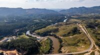 Vista aérea de área atingida pelo rompimento da barragem em Brumadinho com marca de lama e impacto ambiental na paisagem