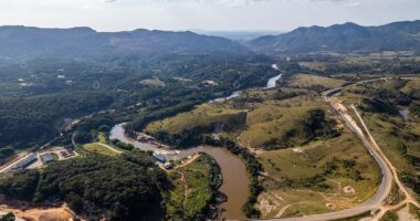 Vista aérea de área atingida pelo rompimento da barragem em Brumadinho com marca de lama e impacto ambiental na paisagem