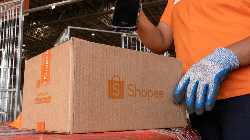 Centro logístico da Shopee acelera entregas em Minas Gerais Funcionário da Shopee realiza leitura de pacote em centro logístico, destacando operação de entregas rápidas em Minas Gerais