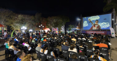 Público assiste a sessão gratuita de cinema ao ar livre durante o programa Cinema na Cidade em praça de Minas Gerais