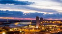 Vista aérea do BH Airport ao entardecer, com terminal iluminado e estrutura aeroportuária na Região Metropolitana de Belo Horizonte