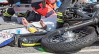 Motocicleta caída na pista enquanto socorristas atendem vítima de acidente de trânsito, ilustrando alta de ocorrências com motos atendidas no João XXIII