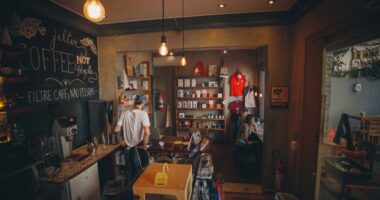 Ambiente interno da Academia do Café, em Belo Horizonte, com espaço dedicado ao universo dos cafés especiais, barista em atendimento e visitantes durante experiência imersiva
