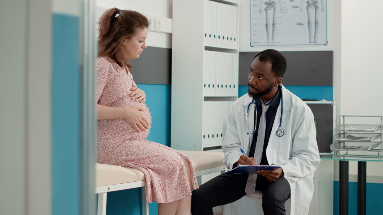 Médico realiza atendimento de pré-natal em gestante durante consulta sobre saúde materna e acompanhamento na gravidez