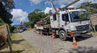 Equipe realiza manutenção e ampliação da rede elétrica da Cemig em município mineiro, com caminhão de serviço e instalação de postes para reforço do fornecimento de energia