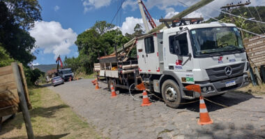 Equipe realiza manutenção e ampliação da rede elétrica da Cemig em município mineiro, com caminhão de serviço e instalação de postes para reforço do fornecimento de energia