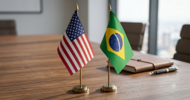 Bandeiras do Brasil e dos Estados Unidos sobre mesa de reunião, representando as relações comerciais entre os dois países em meio à discussão sobre novas tarifas de importação