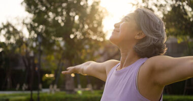 Mulher madura em momento de bem-estar ao ar livre. Queda hormonal da menopausa está associada ao aumento de dores musculares e articulares, condição que pode afetar a qualidade de vida e a mobilidade feminina