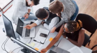 um grupo de pessoas multinacionais ocupadas trabalhando no escritorio
