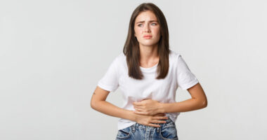 mulher com dores abdominais Freepik