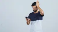 uma pessoa segurando o celular golpes financeiros