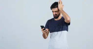 uma pessoa segurando o celular golpes financeiros