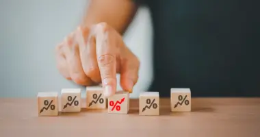 Blocos com símbolos de porcentagem representam a queda na taxa Selic e os impactos dos juros na economia brasileira