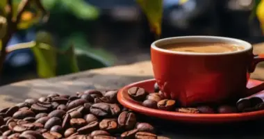 Xícara de café sobre mesa cercada por grãos torrados, imagem que representa o crescimento da produção cafeeira em Minas Gerais e o avanço do consumo da bebida entre jovens