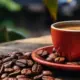 Xícara de café sobre mesa cercada por grãos torrados, imagem que representa o crescimento da produção cafeeira em Minas Gerais e o avanço do consumo da bebida entre jovens