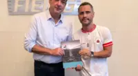 Flávio Roscoe e Cleitinho Azevedo na sede da Fiemg e seguram juntos um documento impresso do Pacto por Minas 2026 sobre as prioridades para a indústria no estado