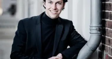 Pianista holandês Nikola Meeuwsen posa de blazer preto e gola alta preta em retrato fotográfico antes da estreia na Orquestra Filarmônica de Minas Gerais