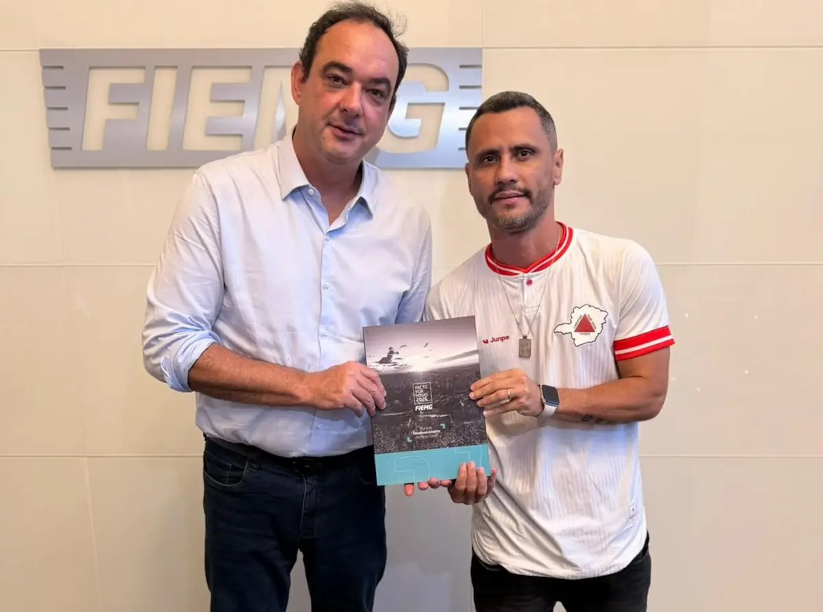 Pacto por Minas 2026 é entregue a Cleitinho Flávio Roscoe e Cleitinho Azevedo na sede da Fiemg e seguram juntos um documento impresso do Pacto por Minas 2026 sobre as prioridades para a indústria no estado